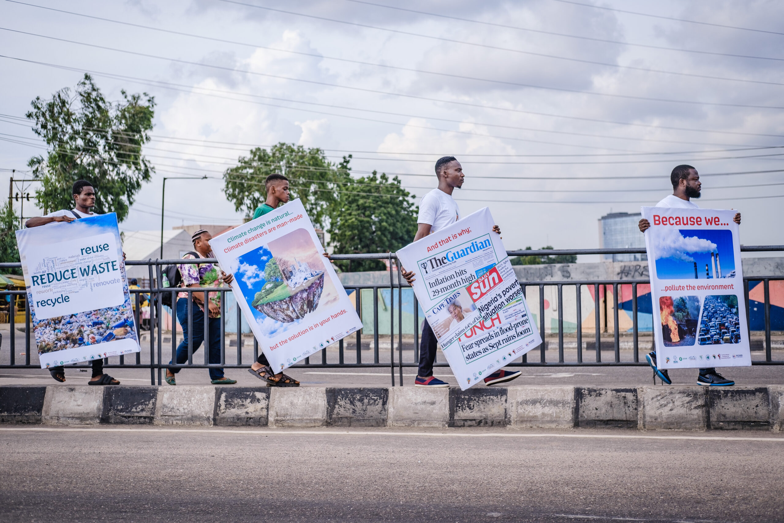LAGOS, NG - OCTOBER 13, 2022: Volunteers carrying printed infographics by the roadside at the caravan climate change walk on October 13, 2022 in Maryland, Lagos State, Nigeria. CREDIT: Taiwo Aina for Oxfam Novib