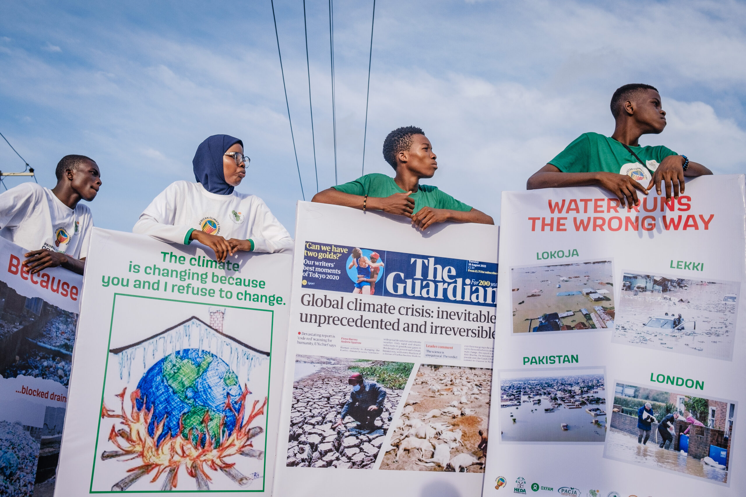 LAGOS, NG - OCTOBER 13, 2022: Volunteers carrying printed infographics by the roadside at the caravan climate change walk on October 13, 2022 in Allen junction, Ikeja, Lagos State, Nigeria. CREDIT: Taiwo Aina for Oxfam Novib