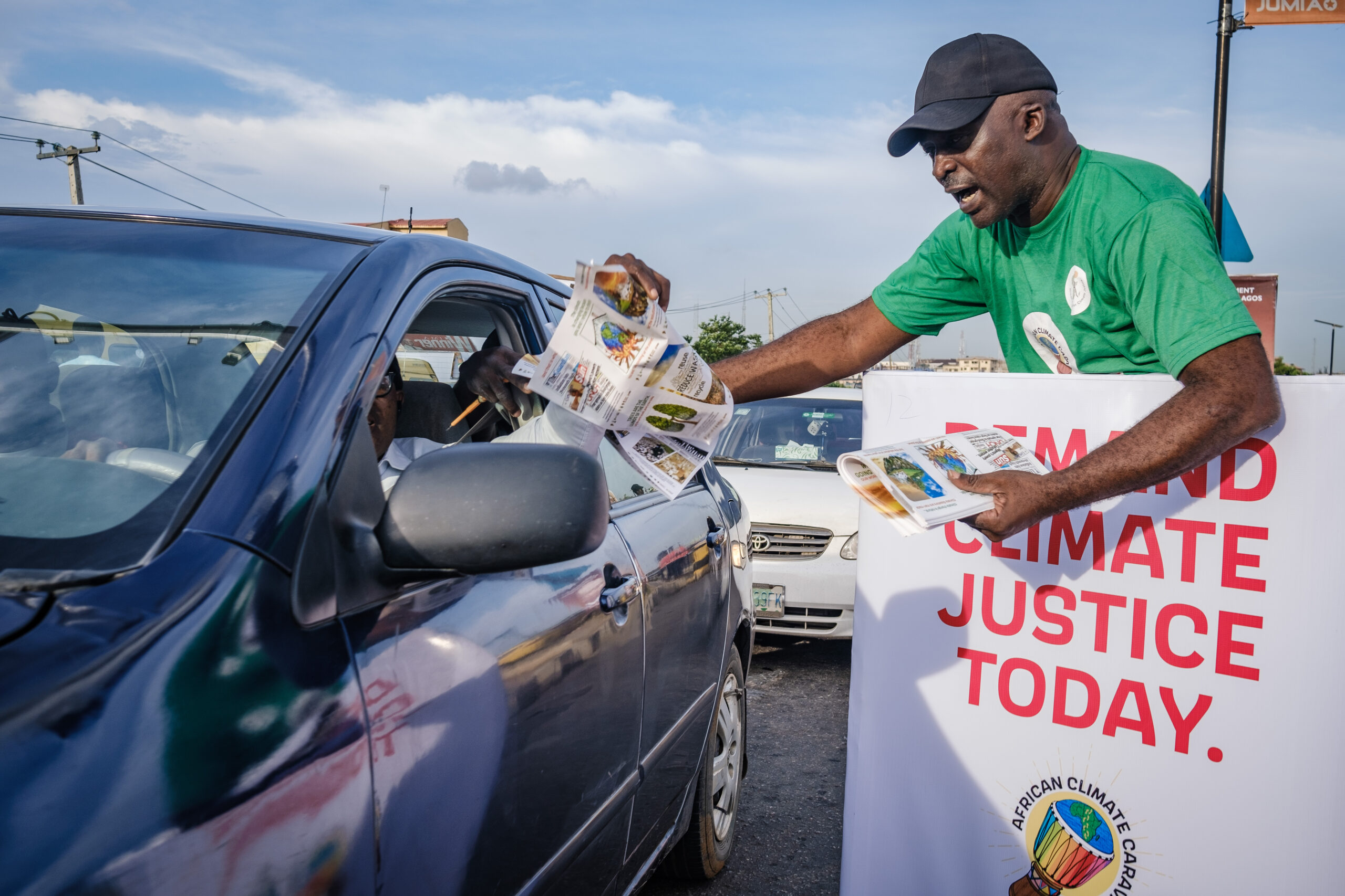 LAGOS, NG - OCTOBER 13, 2022: A volunteer shares pamphlet at the caravan climate change walk on October 13, 2022 in Allen junction, Ikeja, Lagos State, Nigeria. CREDIT: Taiwo Aina for Oxfam Novib